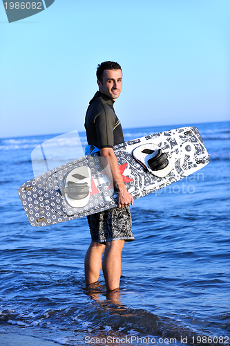 Image of Portrait of a young  kitsurf  man at beach on sunset