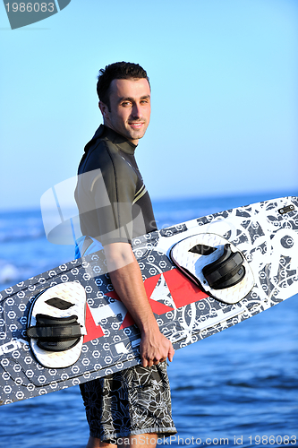 Image of Portrait of a young  kitsurf  man at beach on sunset