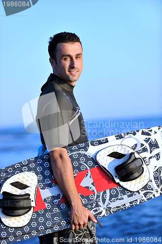 Image of Portrait of a young  kitsurf  man at beach on sunset