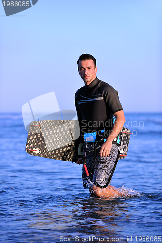 Image of Portrait of a young  kitsurf  man at beach on sunset