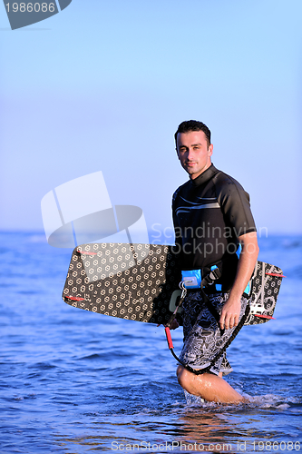 Image of Portrait of a young  kitsurf  man at beach on sunset