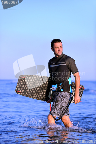 Image of Portrait of a young  kitsurf  man at beach on sunset