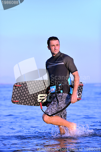 Image of Portrait of a young  kitsurf  man at beach on sunset