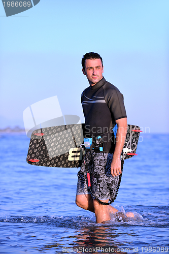 Image of Portrait of a young  kitsurf  man at beach on sunset