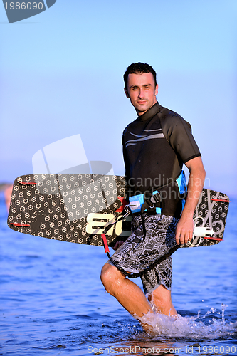 Image of Portrait of a young  kitsurf  man at beach on sunset