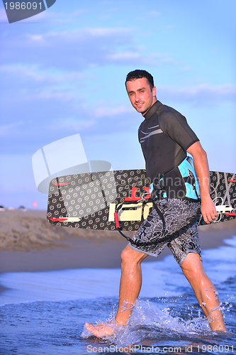 Image of Portrait of a young  kitsurf  man at beach on sunset