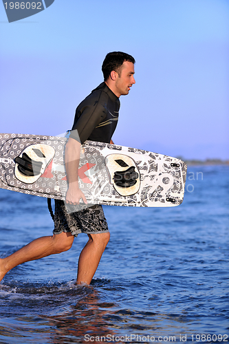 Image of Portrait of a young  kitsurf  man at beach on sunset