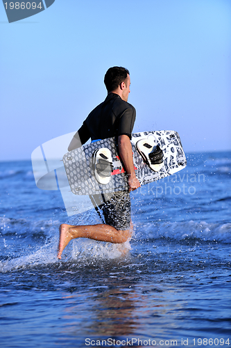 Image of Portrait of a young  kitsurf  man at beach on sunset