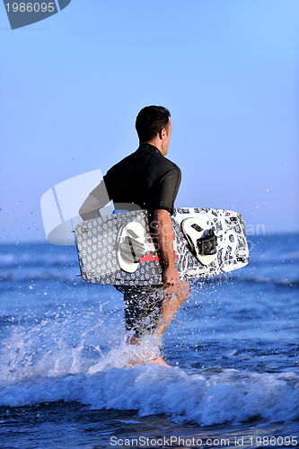 Image of Portrait of a young  kitsurf  man at beach on sunset