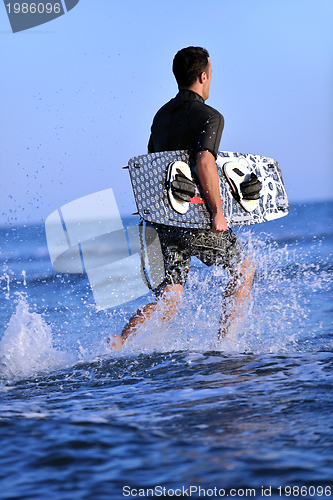 Image of Portrait of a young  kitsurf  man at beach on sunset
