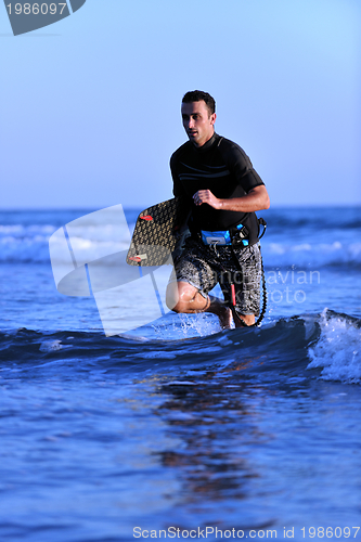Image of Portrait of a young  kitsurf  man at beach on sunset