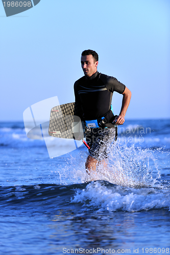 Image of Portrait of a young  kitsurf  man at beach on sunset