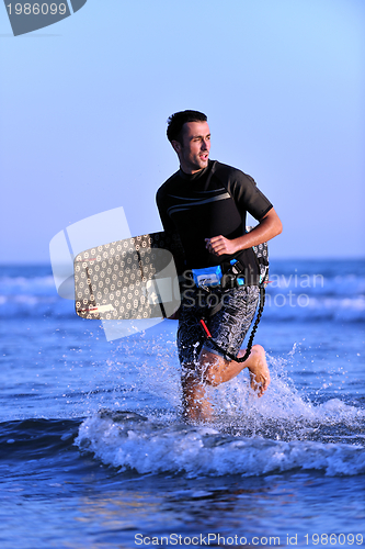 Image of Portrait of a young  kitsurf  man at beach on sunset