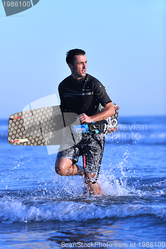 Image of Portrait of a young  kitsurf  man at beach on sunset