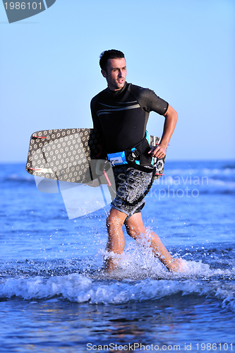 Image of Portrait of a young  kitsurf  man at beach on sunset