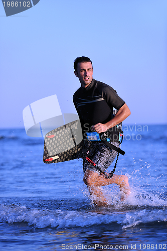 Image of Portrait of a young  kitsurf  man at beach on sunset