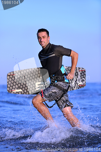 Image of Portrait of a young  kitsurf  man at beach on sunset