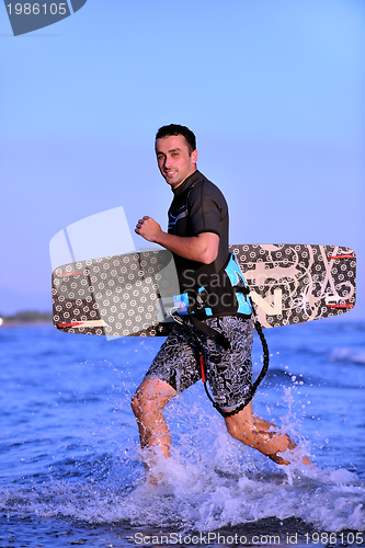 Image of Portrait of a young  kitsurf  man at beach on sunset