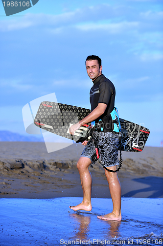 Image of Portrait of a young  kitsurf  man at beach on sunset