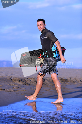 Image of Portrait of a young  kitsurf  man at beach on sunset