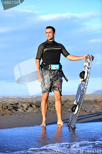 Image of Portrait of a young  kitsurf  man at beach on sunset