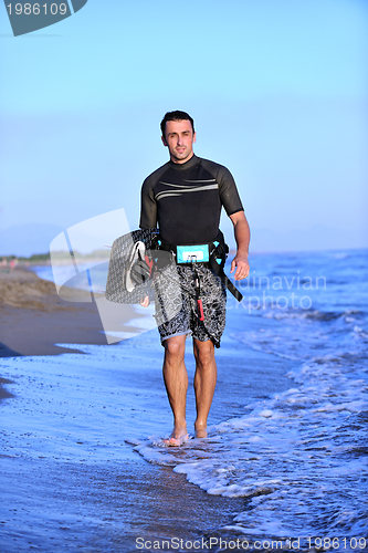 Image of Portrait of a young  kitsurf  man at beach on sunset