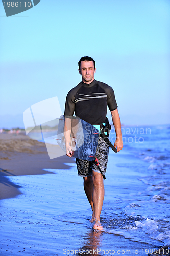 Image of Portrait of a young  kitsurf  man at beach on sunset