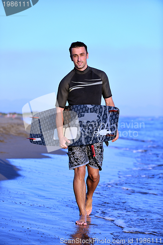 Image of Portrait of a young  kitsurf  man at beach on sunset
