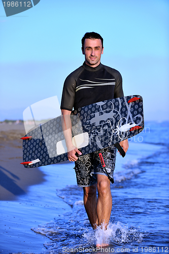 Image of Portrait of a young  kitsurf  man at beach on sunset