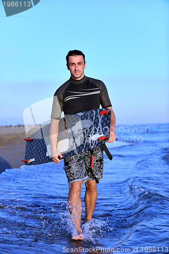 Image of Portrait of a young  kitsurf  man at beach on sunset