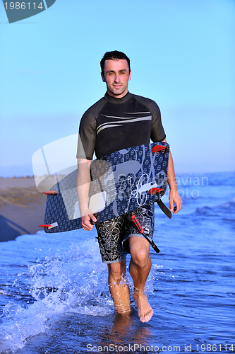 Image of Portrait of a young  kitsurf  man at beach on sunset