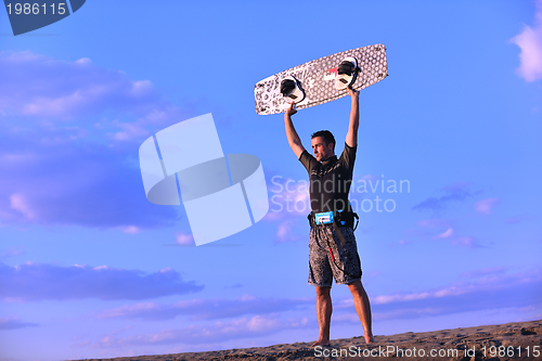 Image of Portrait of a young  kitsurf  man at beach on sunset