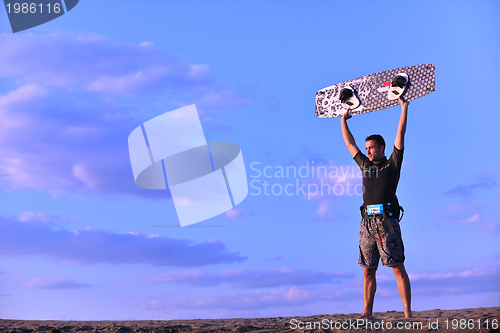 Image of Portrait of a young  kitsurf  man at beach on sunset