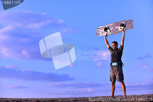 Image of Portrait of a young  kitsurf  man at beach on sunset