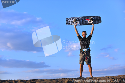 Image of Portrait of a young  kitsurf  man at beach on sunset