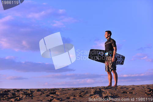 Image of Portrait of a young  kitsurf  man at beach on sunset