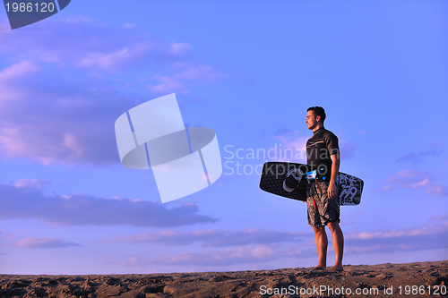 Image of Portrait of a young  kitsurf  man at beach on sunset