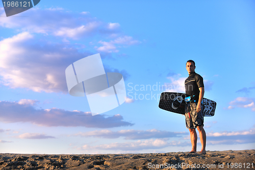 Image of Portrait of a young  kitsurf  man at beach on sunset