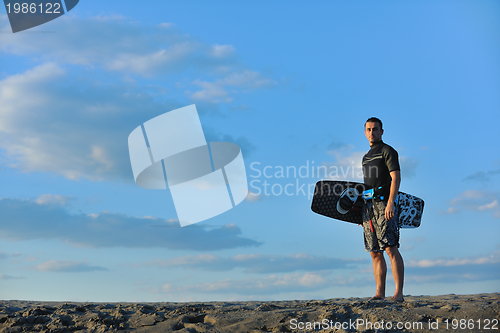 Image of Portrait of a young  kitsurf  man at beach on sunset