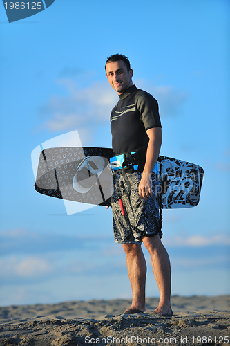 Image of Portrait of a young  kitsurf  man at beach on sunset