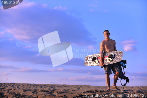 Image of Portrait of a young  kitsurf  man at beach on sunset