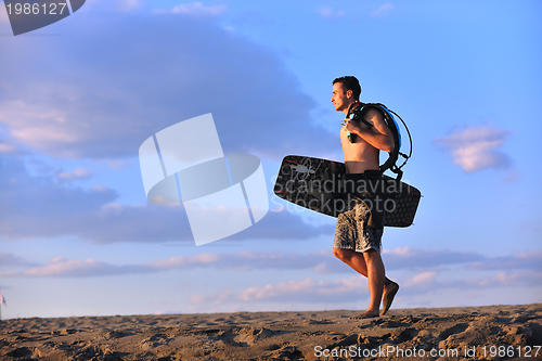 Image of Portrait of a young  kitsurf  man at beach on sunset