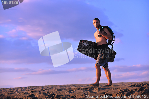 Image of Portrait of a young  kitsurf  man at beach on sunset