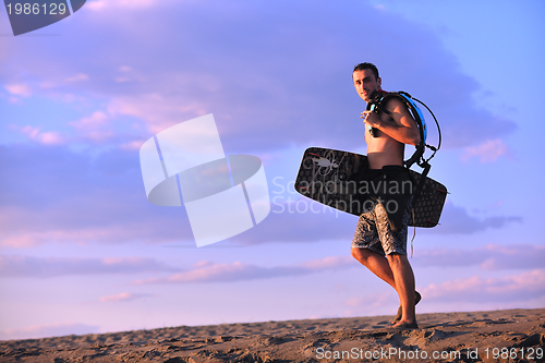 Image of Portrait of a young  kitsurf  man at beach on sunset