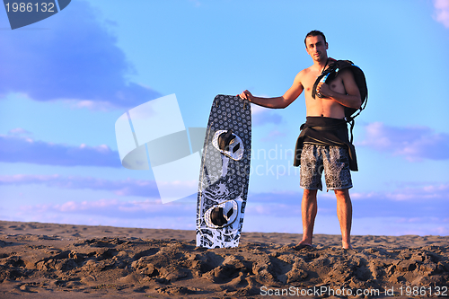 Image of Portrait of a young  kitsurf  man at beach on sunset