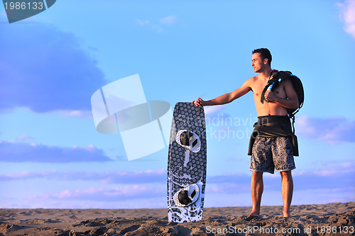 Image of Portrait of a young  kitsurf  man at beach on sunset