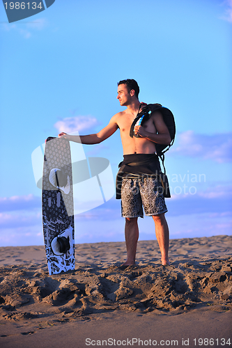 Image of Portrait of a young  kitsurf  man at beach on sunset