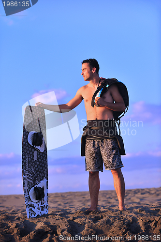 Image of Portrait of a young  kitsurf  man at beach on sunset