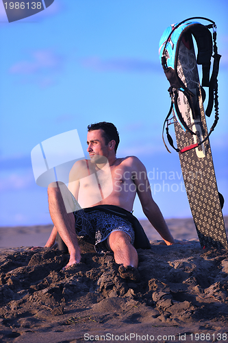 Image of Portrait of a young  kitsurf  man at beach on sunset