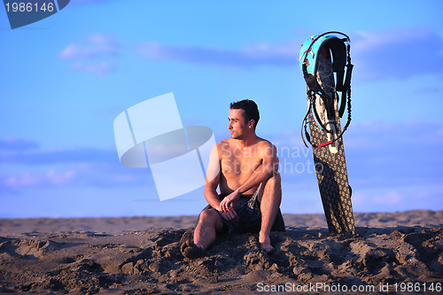 Image of Portrait of a young  kitsurf  man at beach on sunset